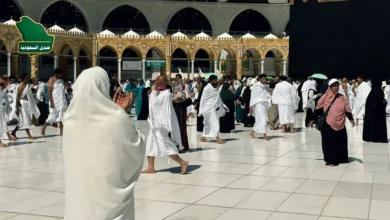 صورة تجمع موظفين سعوديين مبتسمين يرتدون سترات ميدانية موحدة أثناء أداء مهامهم في خدمة حجاج بيت الله الحرام ضمن الوظائف الموسمية لموسم حج.